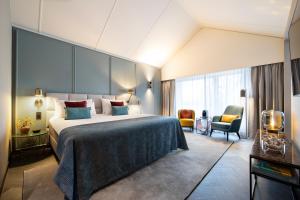 阿珀尔多伦彼尔德伯格酒店的配有一张床和一把椅子的酒店客房