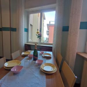 莱圭利亚Appartamento Bergamo的餐桌、一瓶葡萄酒和窗户