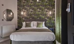 利物浦Home @ 2 Tancred Road的一间卧室配有一张带绿叶壁纸的大床