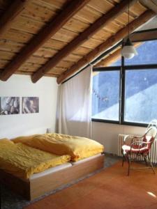 加维科利亚诺Casa Cresmino的卧室配有床、椅子和窗户。