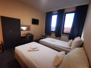 华沙Sieć Hoteli Fort Warszawa的酒店客房配有两张床和一张书桌