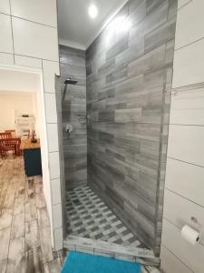 圣卢西亚34 Hornbill Street的带淋浴的浴室(带瓷砖墙)