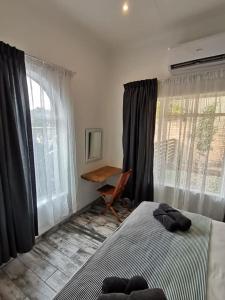 圣卢西亚34 Hornbill Street的卧室配有一张床、一张书桌和窗户。