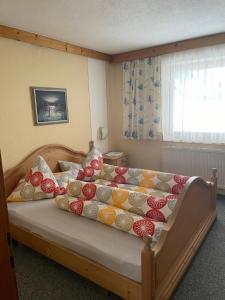 温特维斯霍夫住宿加早餐旅馆的一间卧室配有一张带色彩缤纷枕头的床。