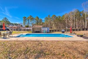 海勒姆Atlanta Area Vacation Rental with Private Pool的庭院内的游泳池,配有桌子和烧烤架