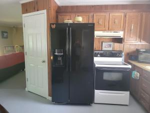 库克维尔The Little House at EVOO的带木制橱柜的厨房内的黑色冰箱