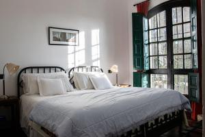 上格拉西亚Hotel El Potrerillo de Larreta的卧室配有带白色枕头的床和窗户。
