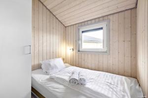 拉科克First Camp Lakolk Strand Camping的一间小卧室,配有带毛巾的床