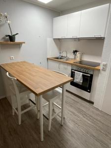 弗罗伊登施塔特Ferienwohnung in Freudenstadt-Kniebis的厨房配有木桌和白色橱柜。