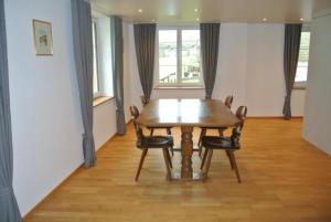 阿彭策尔Ferienwohnung Blaues Haus的一间带木桌和椅子的用餐室
