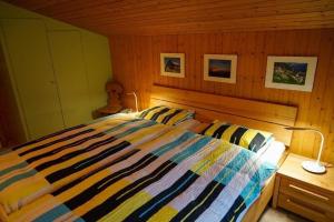 因内特基尔兴4-Bett- Ferienwohnung Brachli的一间卧室配有带条纹被子的床