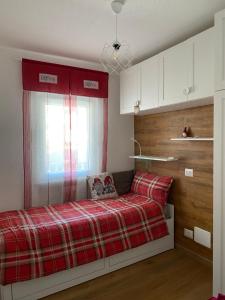 安泰伊-萨伊恩特-安德尔埃Appartamento Antey Saint André posizione centrale的一间卧室配有一张带红色铺面毯子的床