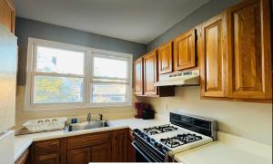 北卑尔根Cozy Apartments close to New York City的厨房配有炉灶、水槽和窗户。