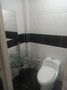 卡利Hotel Avei Suites的一间带卫生间和玻璃水槽的浴室