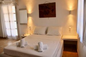 考弗尼西亚Iliovasilema Studios Koufonisi的卧室配有白色的床和2条毛巾