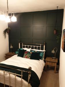 弗姆比Dora Cottage的一间卧室设有一张带绿色墙壁的大床