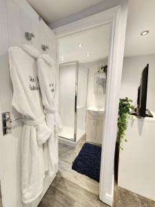 科恩布鲁克Studio Apartment The Den Colnbrook的浴室设有挂在门上的白色毛巾