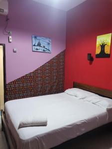 比绍HOTEL BADINCA Alojamento Low Cost in Bissau avenida FRANCISCO MENDES的卧室配有白色的床铺和红色的墙壁