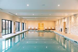 科涅克Hôtel Chais Monnet & Spa的一座带窗户的别墅内的游泳池和一座室内游泳池