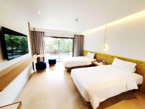 港生Novotel Rayong Rim Pae Resort的酒店客房设有两张床和窗户。