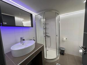 亚历山德鲁波利斯Supreme City Heart Suites的白色的浴室设有水槽和淋浴。