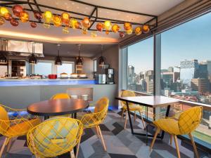 首尔ibis Styles Ambassador Seoul Myeong-dong的设有带桌椅的厨房,享有城市美景。