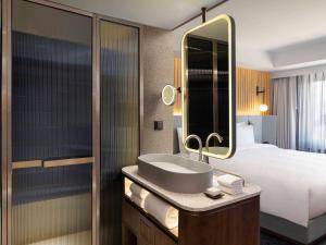 首尔蒙德里安首尔梨泰院街酒店的一间带水槽、床和镜子的浴室