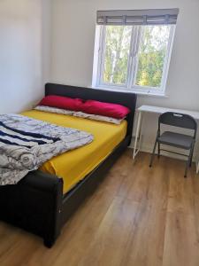 KentLangley Haven - 3 BR House的卧室配有床、椅子和窗户。