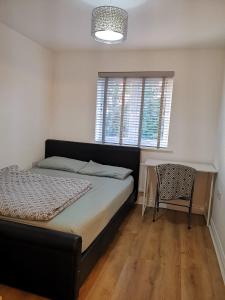 KentLangley Haven - 3 BR House的卧室配有1张床、1张桌子和1把椅子