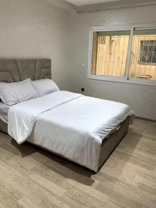 卡萨布兰卡chez maroine的卧室配有一张大白色床和窗户