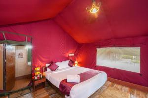 蒙纳自然区丛林度假村的一间红色帐篷内的卧室