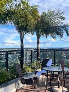 马瑙斯APART HOTEL SENSE II - Localizado em Hotel的一个带桌椅和棕榈树的庭院