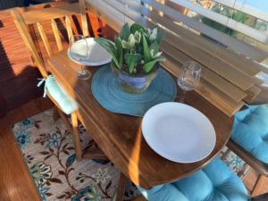 SavannaThe Lily Pad Boatel Houseboat的一张木桌,上面有盘子和花瓶
