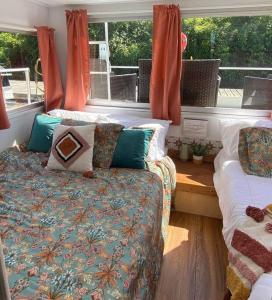 SavannaUnique and Serene Sunset Houseboat for 4的客房设有两张床、一张沙发和一个窗口。