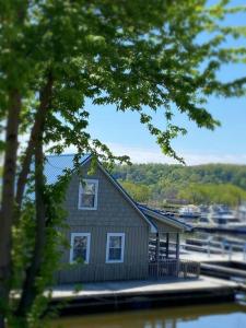 SavannaFloating Cottage on the River Nantucket的码头上的房屋,码头上设有船只