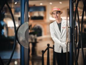 深圳深圳威尼斯英迪格酒店的站在公共汽车旁戴帽子的女人