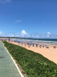 萨尔瓦多FLAT ENCANTADOR A UM PASSO DA PRAIA的海滩上设有椅子和遮阳伞,还有大海