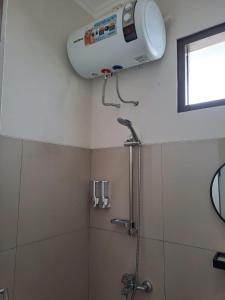 万隆Tabebuya Rumah Liburan Keluarga的带淋浴的浴室(墙上配有风扇)