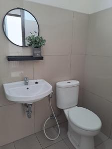 万隆Tabebuya Rumah Liburan Keluarga的一间带卫生间、水槽和镜子的浴室