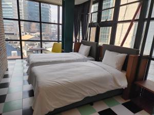 首尔LE SEOUL HOTEL的配有大窗户的酒店客房内的两张床