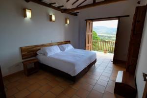 巴里查拉CASA LLANO HIGUERAS的一间卧室设有一张床,并有通往阳台的门