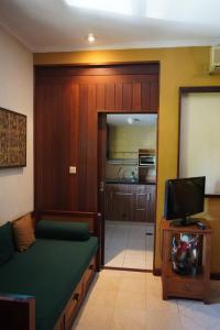 努沙杜瓦茅棚阿贡住宿加早餐旅馆的客厅配有沙发和电视。