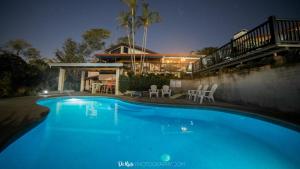阿拉胡埃拉Villas Aracari的房子前面的蓝色游泳池