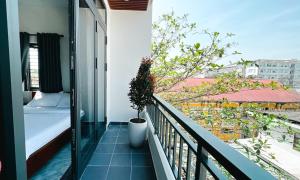 顺化Mini hotel Lạc Hồng的阳台,上面有床和植物