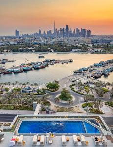 迪拜班达阿炎罗塔纳 - 迪拜河酒店的享有城市和河流及游泳池的景色