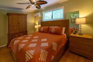 科洛阿幽隐湾坡伊普海滩酒店的一间卧室配有一张床和吊扇