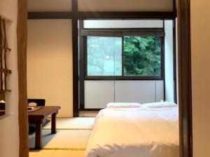箱根SyunkaSyuutou - Vacation STAY 53638v的一间卧室设有一张床、一个窗口和一张桌子