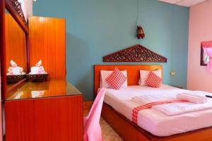 甘烹碧โรงแรม พี รีสอร์ท的一间卧室配有一张大床和镜子