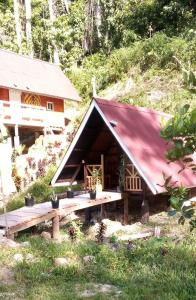 圣维森特Tentstar Eco Resort的一间设有红色屋顶和野餐桌的小房子