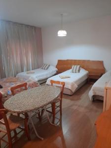 拉纳卡奥妮思罗斯酒店的一间设有两张床和一张桌子及椅子的房间